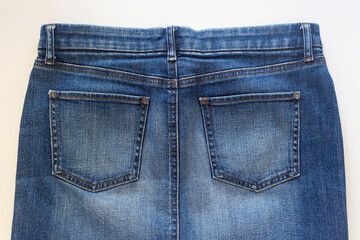 Closed-up of back view of jean skirt on a white background.