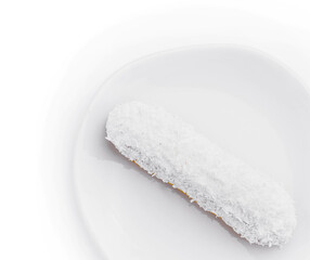 eclair in white glaze and coconut flakes