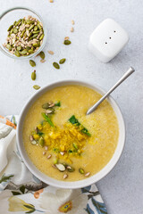 Healthy lunches, cream soup of yellow and orange lentils with fried onions and spinach leaves and curry, useful legums, top view