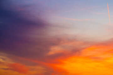 Naklejka na ściany i meble Beautiful sunset sky with amazing colorful clouds against deep blue