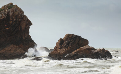 Beach at nervous Atlantic Ocean with big waves before a storm. Photo from Ursa Beach in Portugal.