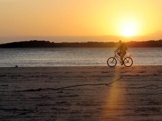 Obraz premium silhouette of a cyclist on the beach