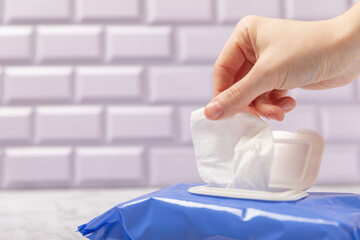 Packing wet wipes in hands on background. An open pack of hand and body wipes. Mockup. A clean...