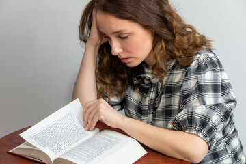A young white woman is reading The second book of Moses, called Exodus in a bilingual,...