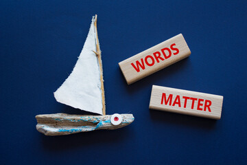 Words Matter symbol. Concept word Words Matter on wooden blocks. Beautiful deep blue background...