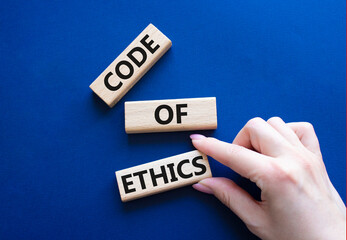 Code of ethics symbol. Concept words Code of ethics on wooden blocks. Beautiful deep blue...