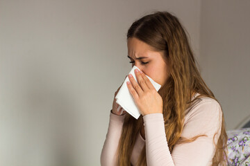 Portrait Of Ill Woman Caught Cold. Woman is sneezing. Paper napkin.