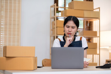 A young female entrepreneur feels stressed about selling products online and preparing to send them to customers. Online selling at home, working from home