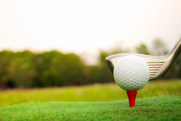 Golf ball placed on grass, background with bokeh and flare.