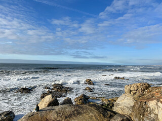 Fototapeta na wymiar Rocks on the beach and sea waves on a sunny day in Porto coast, Portugal. Beautiful sea.