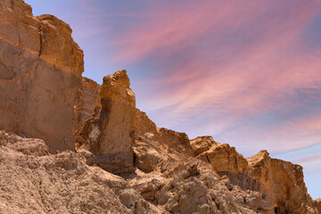 Landscape rocky formations are jagged and weathered, indicating geological changes over time. The...