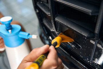 Guy cleans a car air duct with a special brush