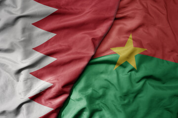 big waving national colorful flag of burkina faso and national flag of bahrain.