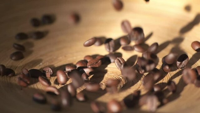 Beautiful time-lapse footage of falling coffee beans 4K. Slow motion of roasted coffee beans falling. Organic coffee seeds.