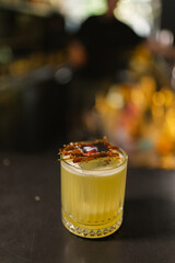 Spicy cocktail with hints of cinnamon based on Gin and tropical fruits. Craft beverage created by experienced bartender closeup