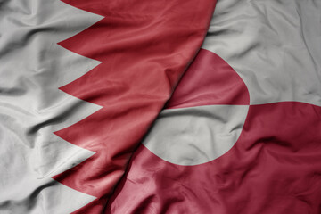 big waving national colorful flag of greenland and national flag of bahrain.