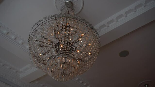 A grand chandelier adorns the ceiling, adding symmetry and elegance to the room