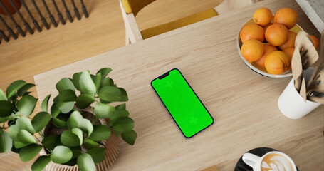 Smartphone place on kitchen table, Green screen telephone, Close up display mobile phone with mock up, Chroma key monitor