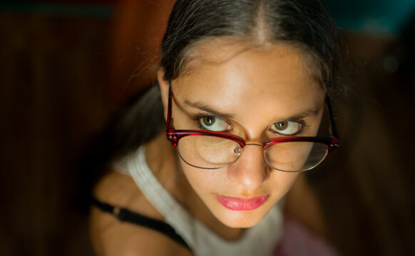 primer plano de joven mujer con lentes mirando seria 