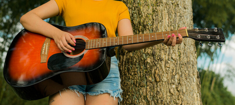 mujer tocando la guitarra al aire libre 