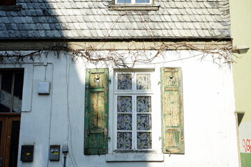 Alter Fensterladen aus Holz mit abblätternder Farbe in Grün eines romantischen Altbau in einem Hinterhof in der Schulstraße im Stadtteil Sachsenhausen in Frankfurt am Main in Hessen