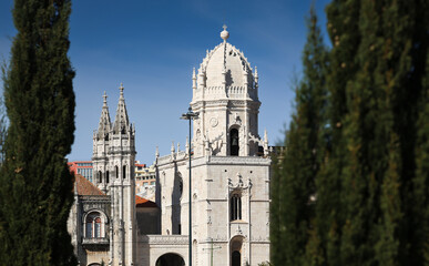 Jeronimos Monastery in Lisbon and Santa Maria de Belem Church landmark buildings in a photo during a sunny day with blue sky. Travel to Lisbon, Portugal.
