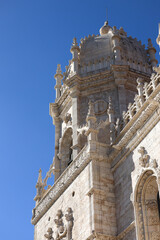 Obraz premium Jeronimos Monastery in Lisbon and Santa Maria de Belem Church landmark buildings in a photo during a sunny day with blue sky. Travel to Lisbon, Portugal.