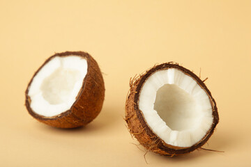 Coconut with half on beige background. Space for text