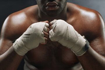 Dramatic close up of African American fighter with hands wrapped in bandages