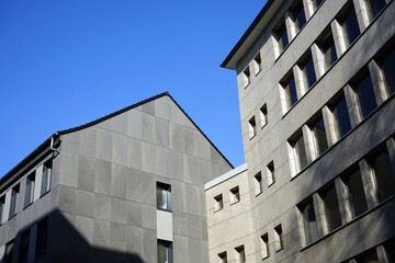 Sanierte Bürogebäude mit Fassadenverkleidung in hellem Grau vor blauem Himmel im Sonnenschein am Großen Hirschgraben in der City und Innenstadt von Frankfurt am Main in Hessen