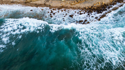 Dark-blue ocean wave crashing onto the rocky shore. Cantabria, Spain. - obrazy, fototapety, plakaty