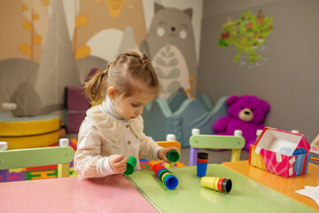 Little Girl Playing with Colorful Stacking Cups
