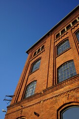 Fensterfront einer alten Fabrik mit Fassade aus Backstein vor blauem Himmel im Sonnenschein in der Klassikstadt im Stadtteil Fechenheim in Frankfurt am Main in Hessen
