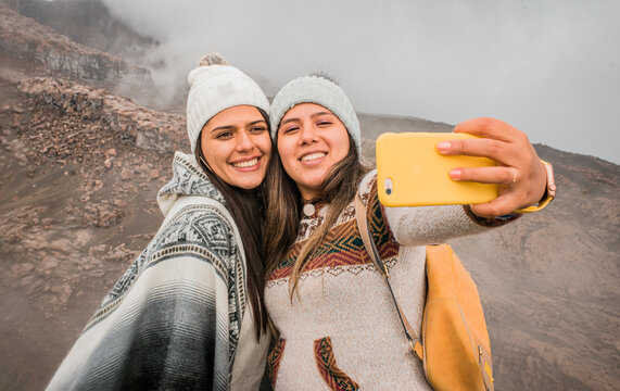 retrato de dos amigas felices tomando auto foto de vacaciones en la montaña con el celular 