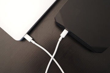 Close-up. Charging battery laptop from external charger power bank. 