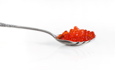 Red salmon caviar or roe on a vintage spoon, white background