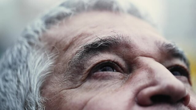 Contemplative gaze of senior man close-up eyes looking up with HOPE and FAITH. wrinkled aged Spiritual older person looking UPWARDS
