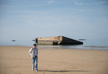 Young girl with backpack sightseeing along the coast of Normandy, France where Operation Overlord...