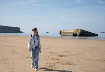 Happy young girl walking and watching while sightseeing along the coast of Normandy, France where...