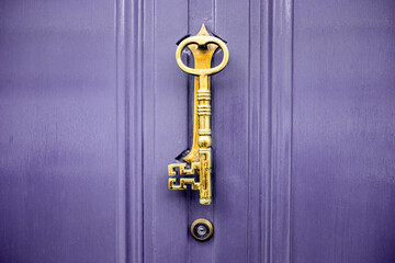 Key shaped door knocker on British house front door
