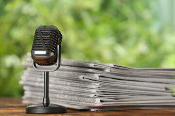 Newspapers and vintage microphone on table. Journalist's work