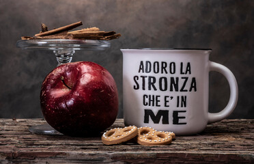 cup of tea on a table with cookies , apple and pomander