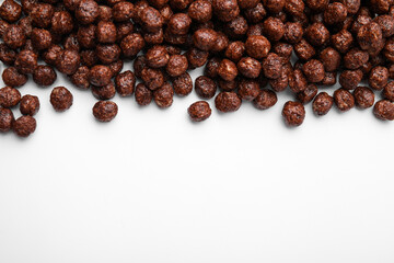 Tasty chocolate cereal balls on white background, flat lay. Space for text