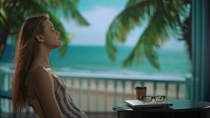 A woman working remotely and traveling. Young female freelancer, resting with her eyes covered and enjoying the moment, side shot.