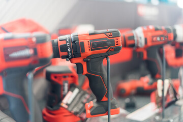 Power tools, drills and hammers of various manufacturers are sold in a hardware store.
