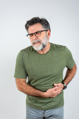 A mature man touching his stomach, on gray background with copy space. Stomach pain and others...
