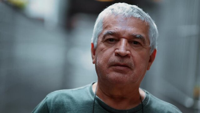 One elderly senior man close-up face with neutral expression depicting old age, 70s male person with gray-hair and wrinkles