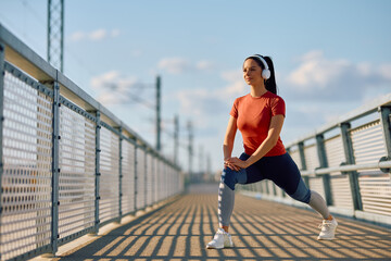 Young sportswoman warming up while working out outdoors.