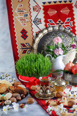 Traditional Azerbaijan holiday Novruz background with green semeni,traditional azerbaijan sweets,shekerbura,qogal,paxlava,mutaki and different nuts and sweets,top view,space for copy
