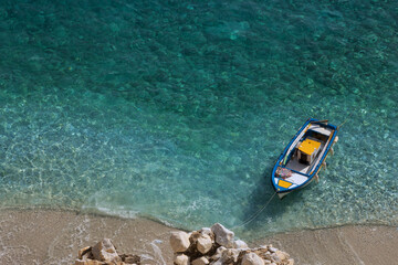 beach scene with aquamarine clear water and tiny boat, Seychelles beach, Ikaria island,  North...